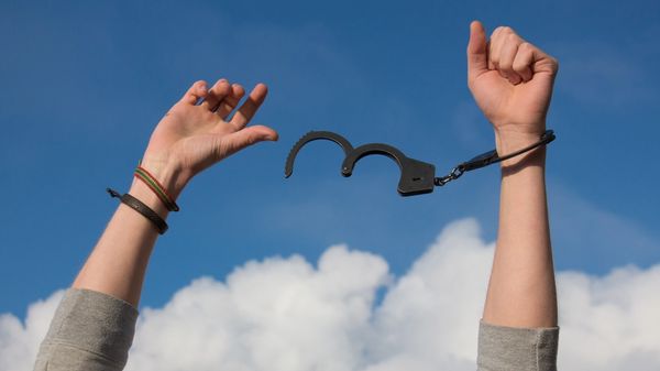 Image of hand unshackled by handcuffs