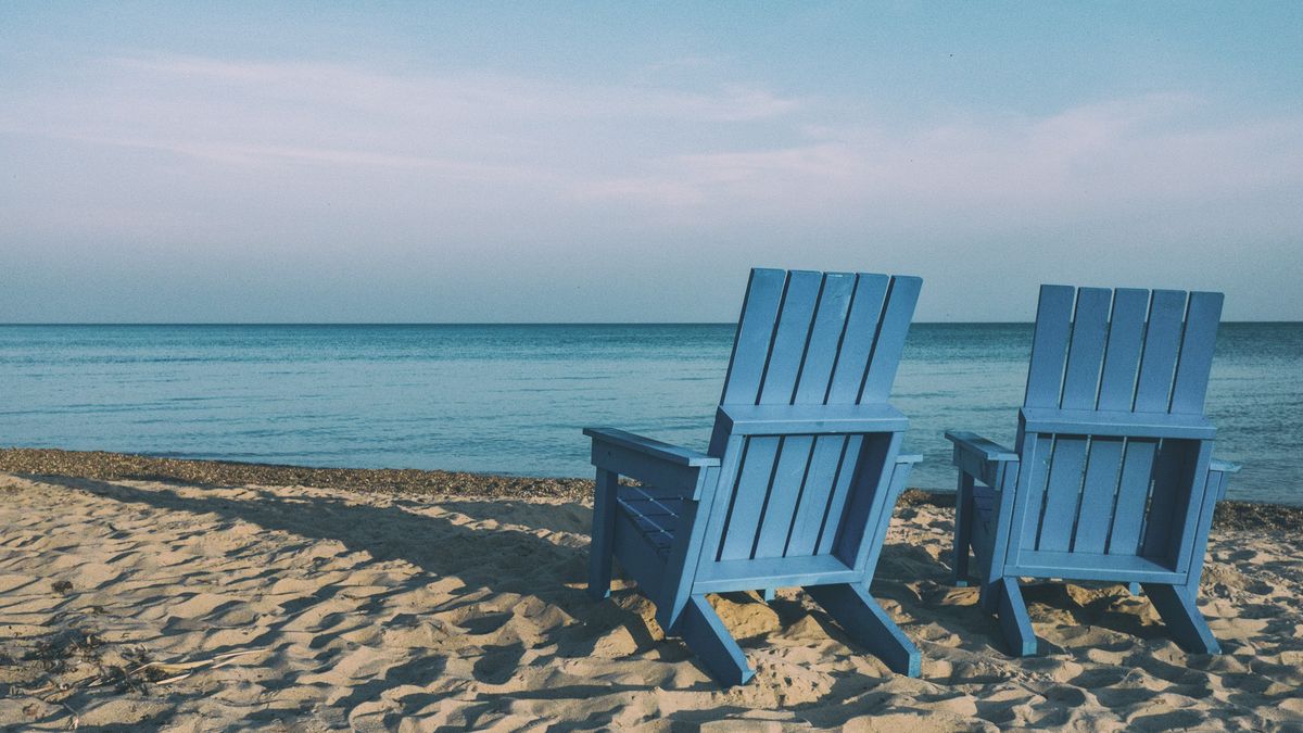 Two chairs on a beach.
