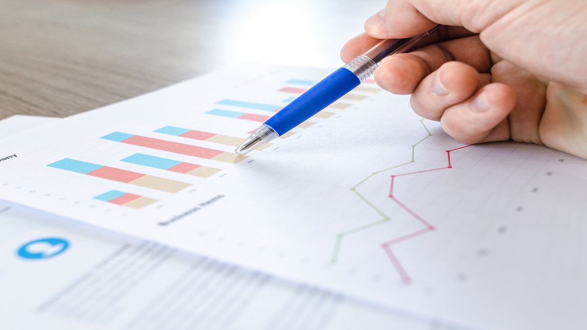 A pen writing on a spreadsheet