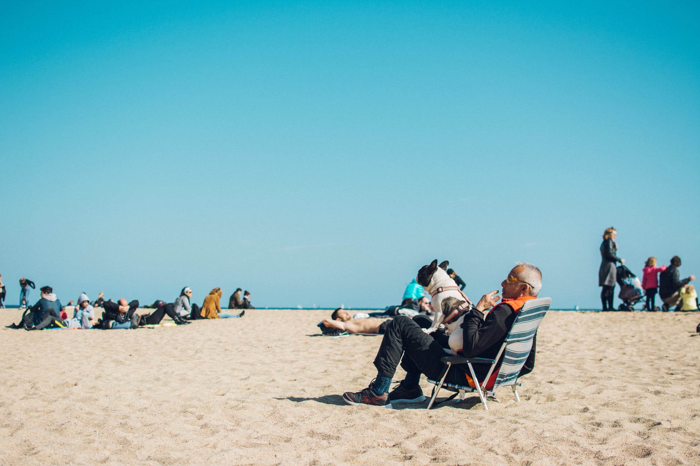 A retired couple sitting on lawn chairs on the beach