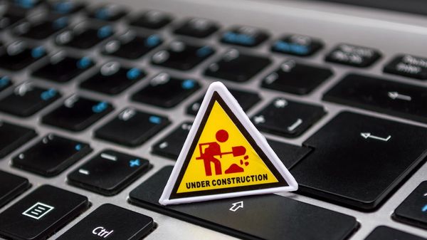 A computer keyboard with an "under construction" sign on it.