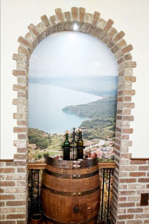 Troika Restaurant display nook with wine barrel and custom mural background