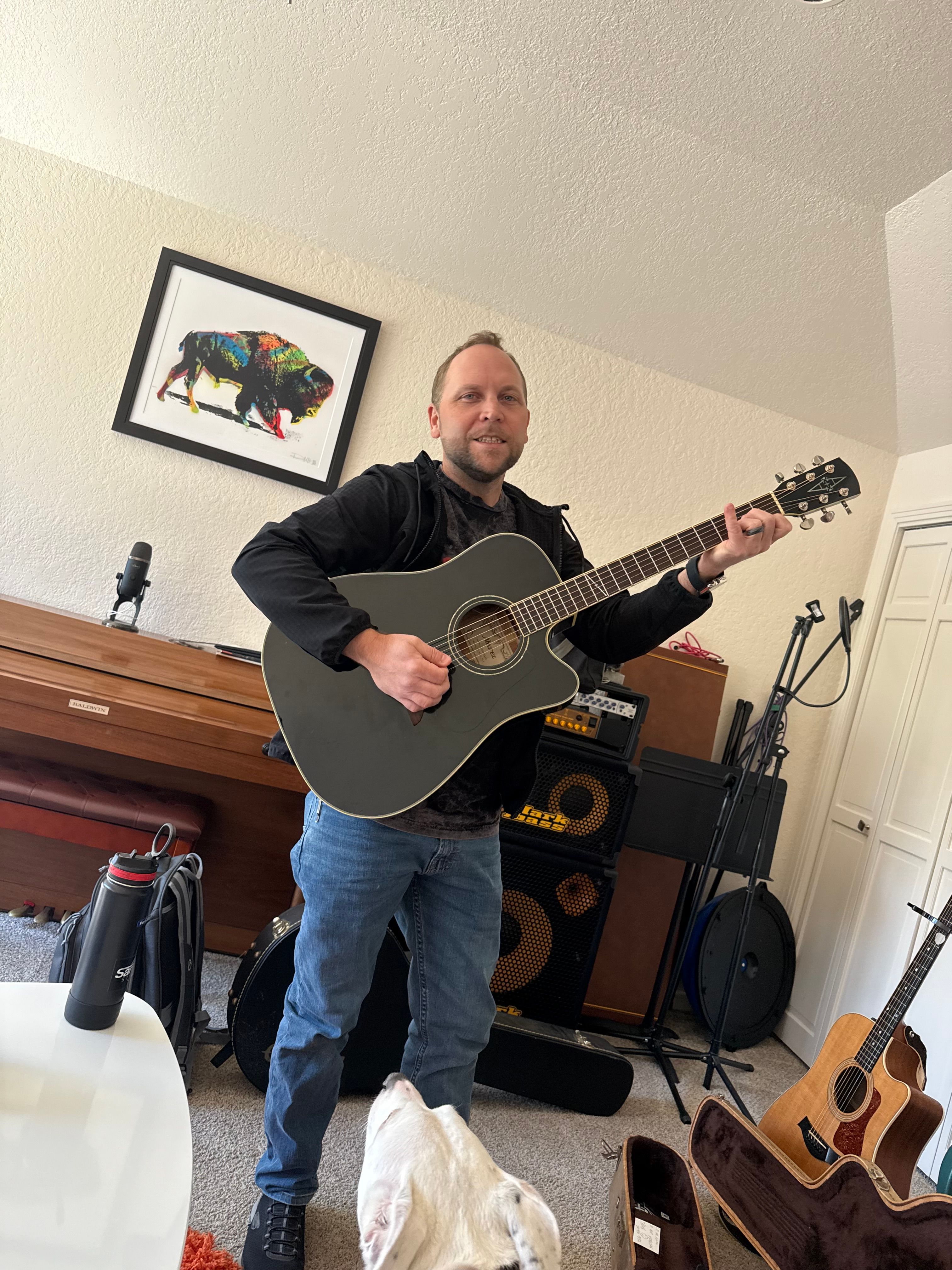 A musician working through an acoustic guitar part during the writing process