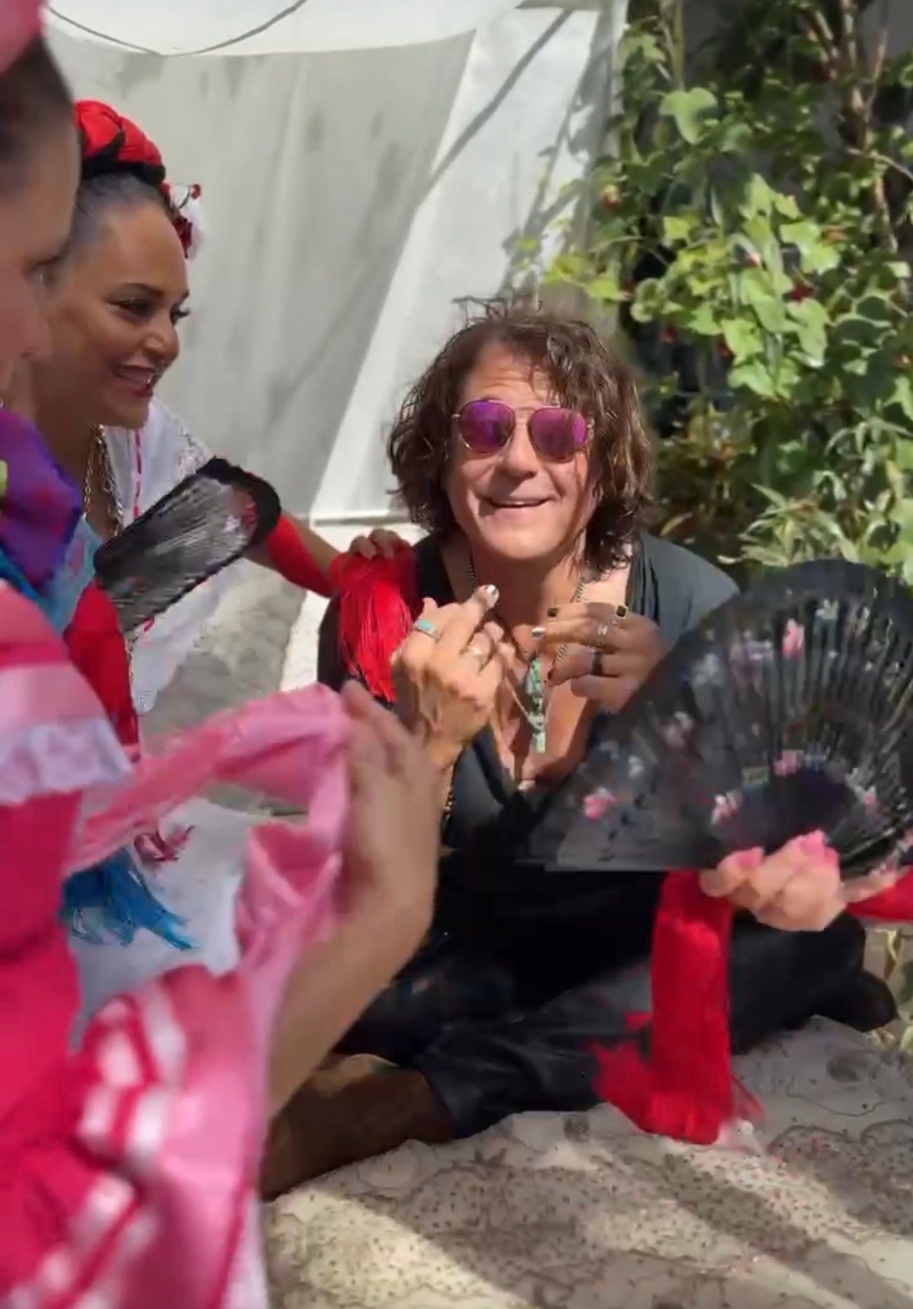 A colorful ceremonial scene with fans and dancers from the “Mexico” music video