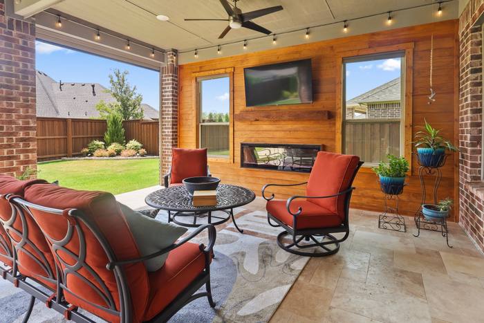 Covered patio with a fireplace wall, The Colony. Built by True Star Outdoor Solutions.