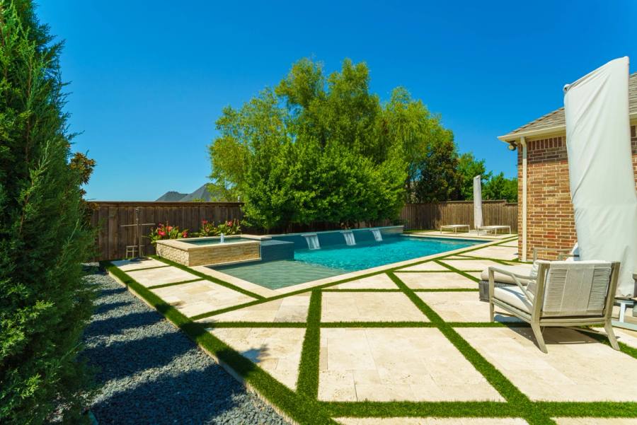 Pavers and turf around a pool in Frisco. Built by True Star Outdoor Solutions.