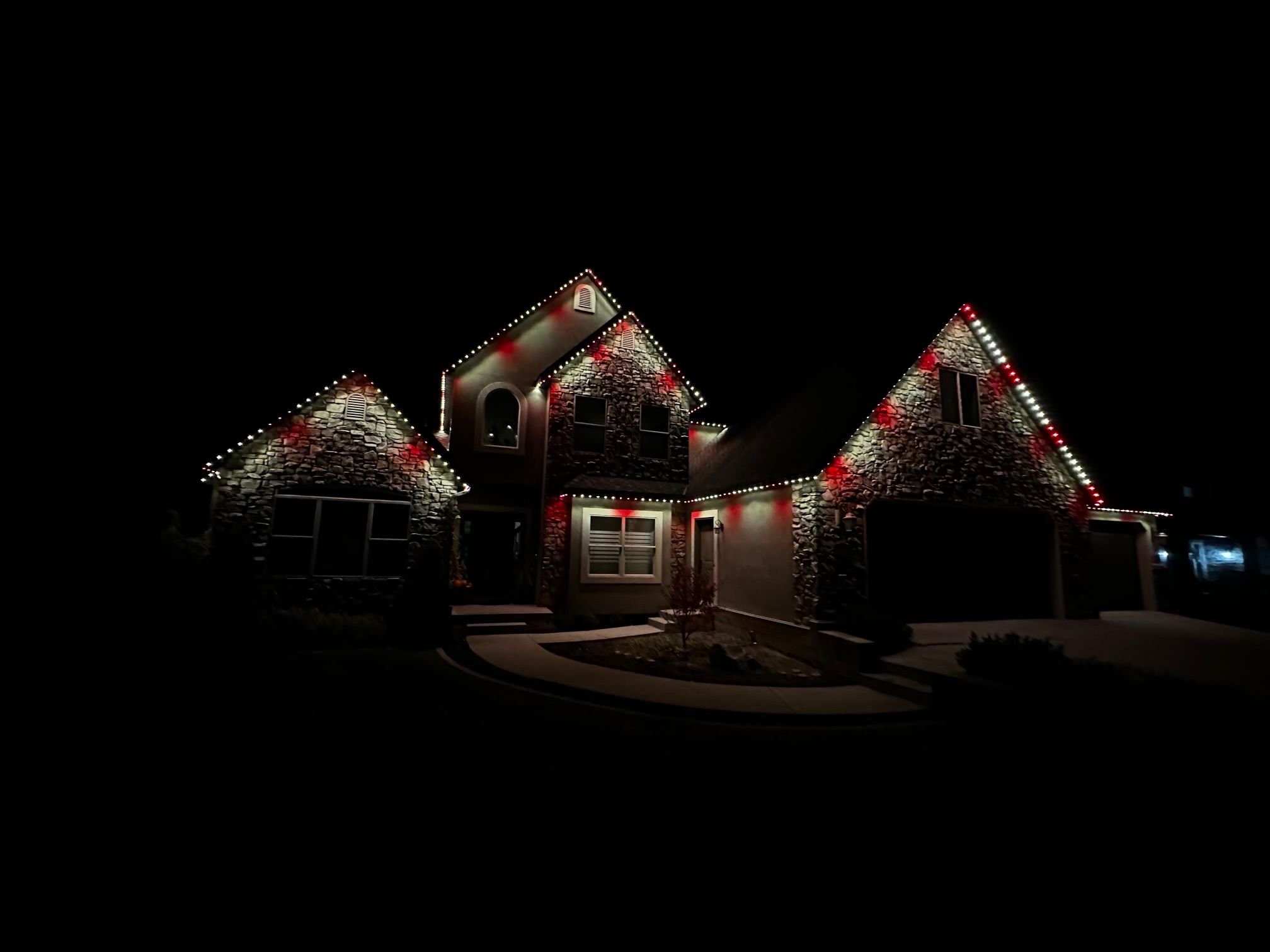 Permanent outdoor Christmas lights illuminating the roofline of a Utah home at night.