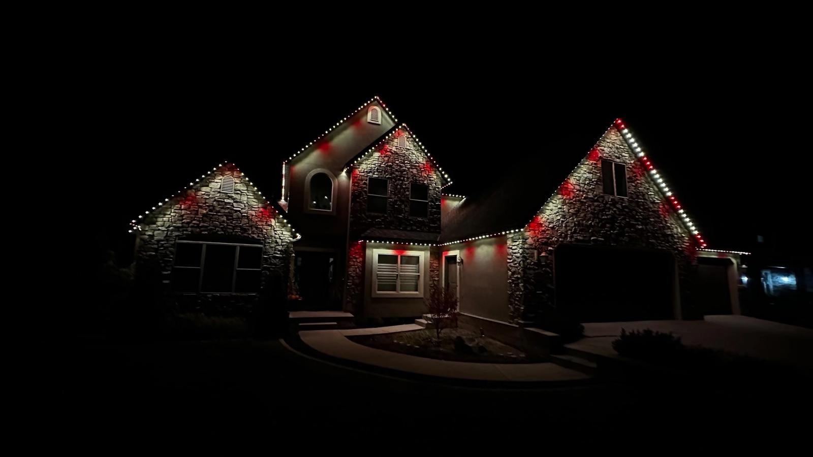 Permanent outdoor Christmas lights illuminating the roofline of a Utah home at night.