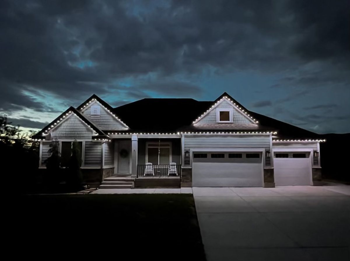 Utah home illuminated with permanent outdoor LED lights at dusk.