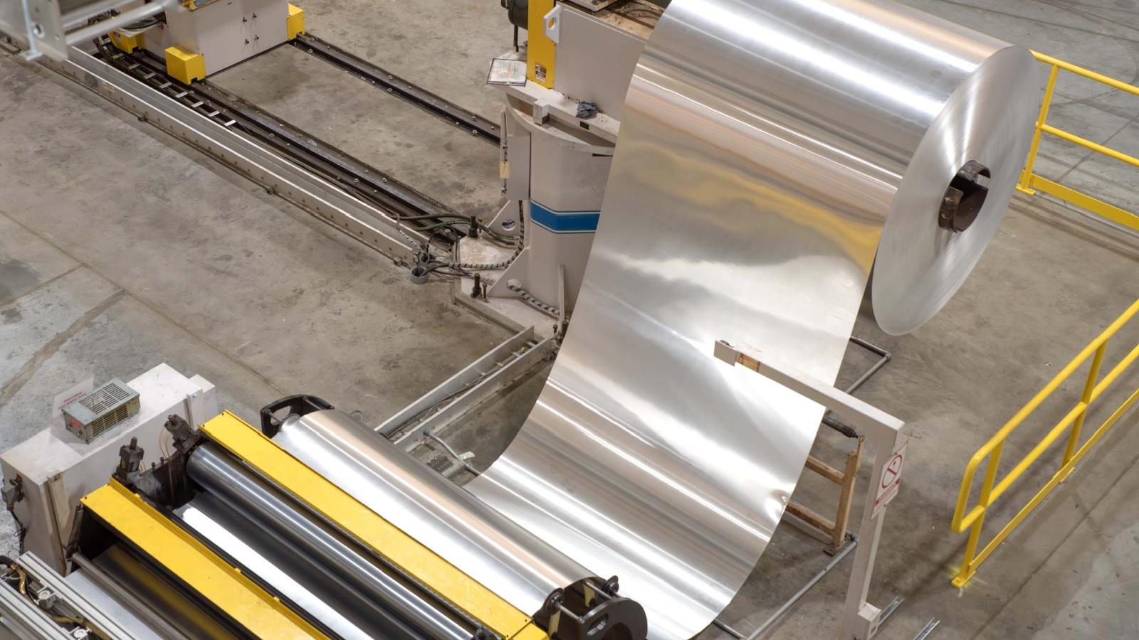 an aerial image of a machine rolling sheets of aluminum at an aluminum can manufacturing plant