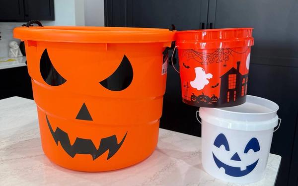 Halloween buckets from Lowes, Home Depot and Petco lined up on a shelf