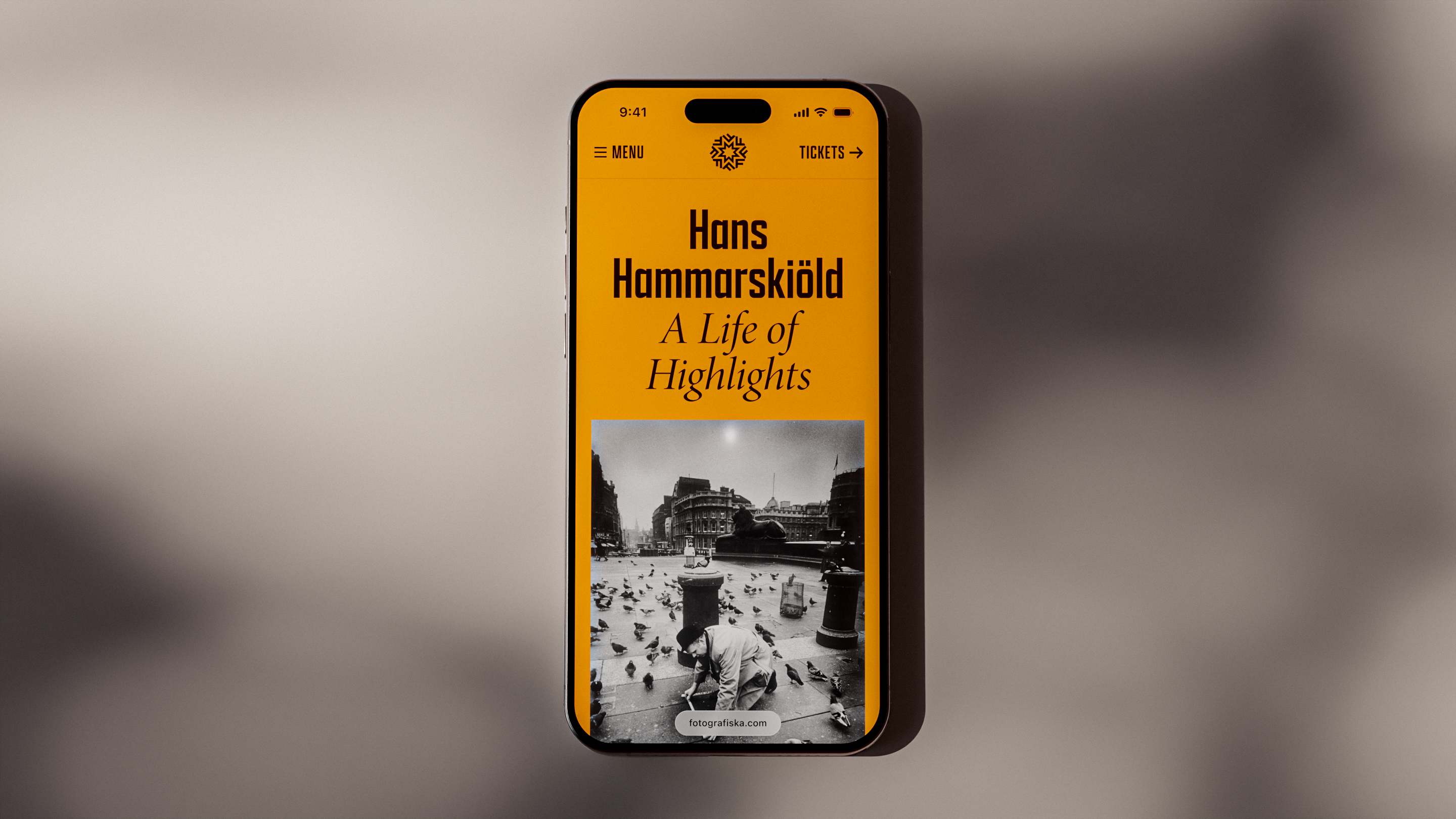 A smartphone displaying a yellow and black mobile website interface for 'Hans Hammarskiöld: A Life of Highlights,' featuring a vintage black-and-white photograph of a city square with pigeons and classical architecture.