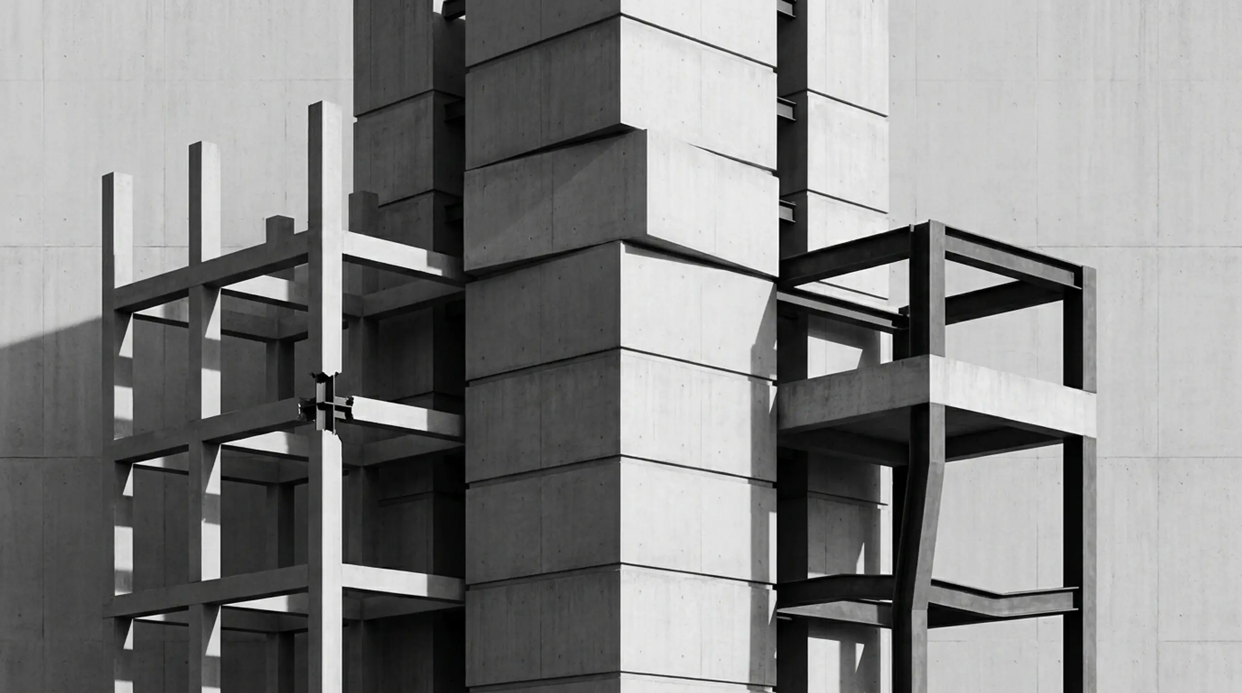 Black and white image of a brutalist concrete building, showing strong geometric forms and deep shadows.