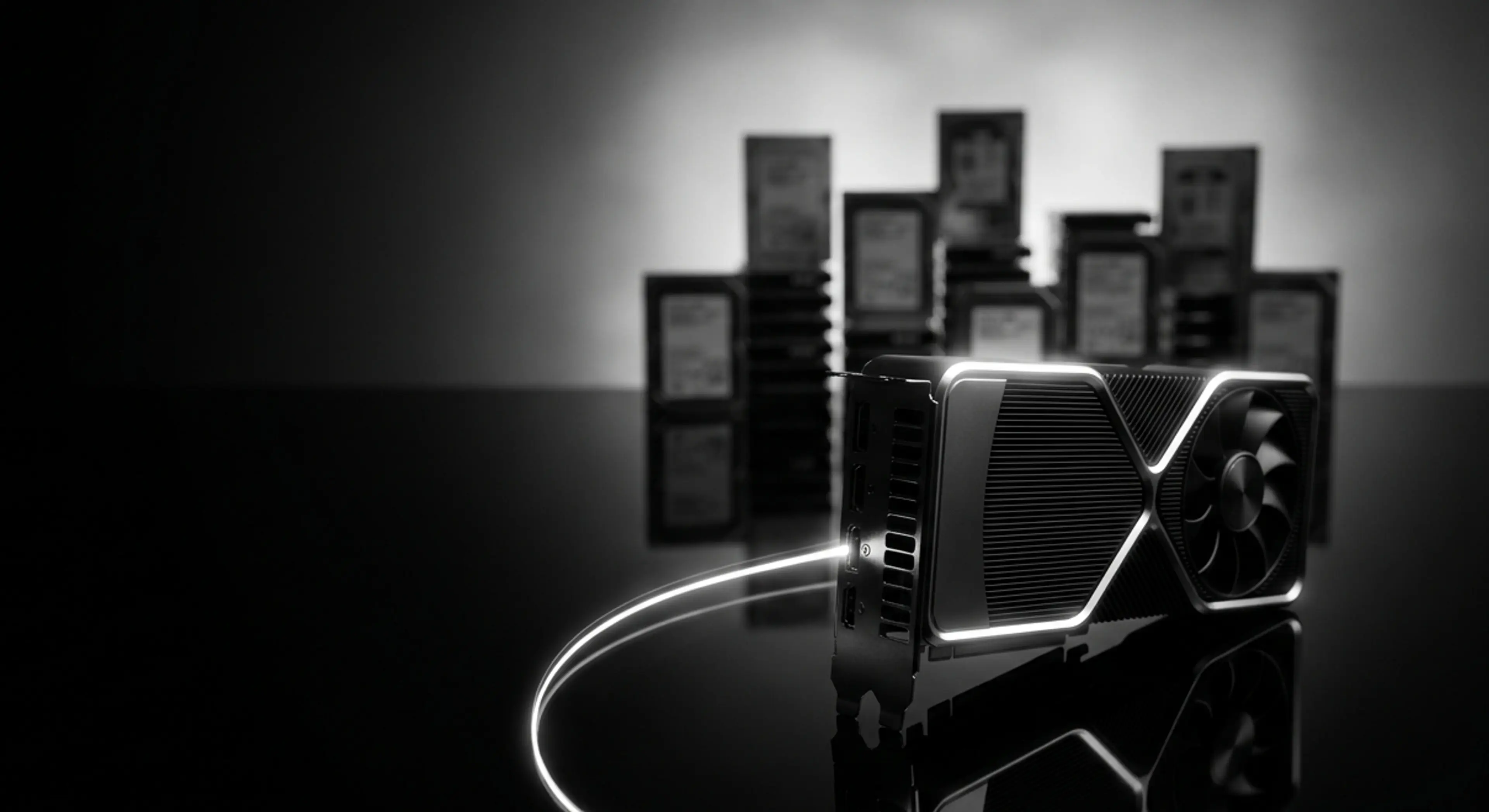 A glowing black GPU on a reflective surface with a light trail and blurred background of stacked circuit boards.