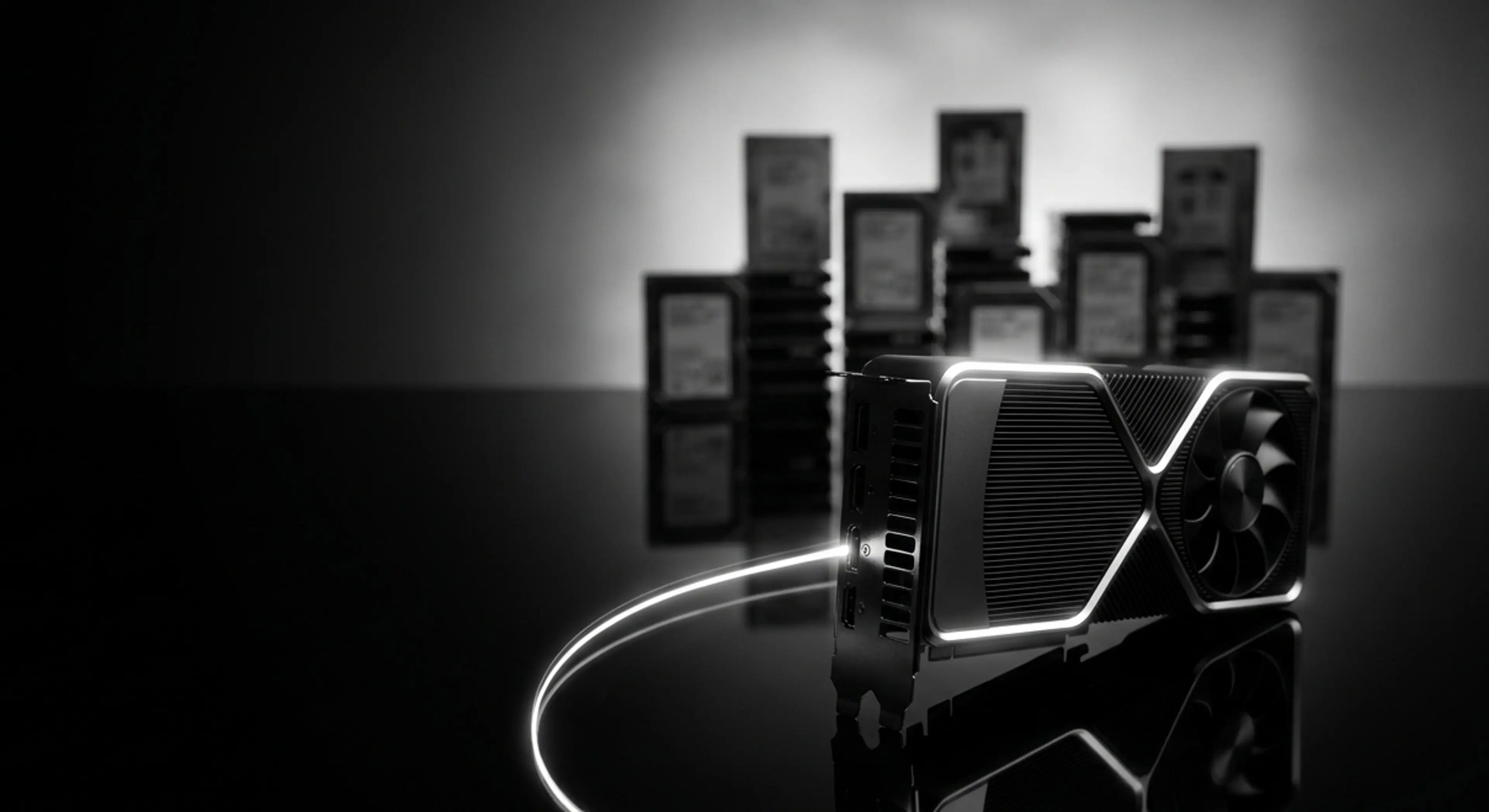 A glowing black GPU on a reflective surface with a light trail and blurred background of stacked circuit boards.