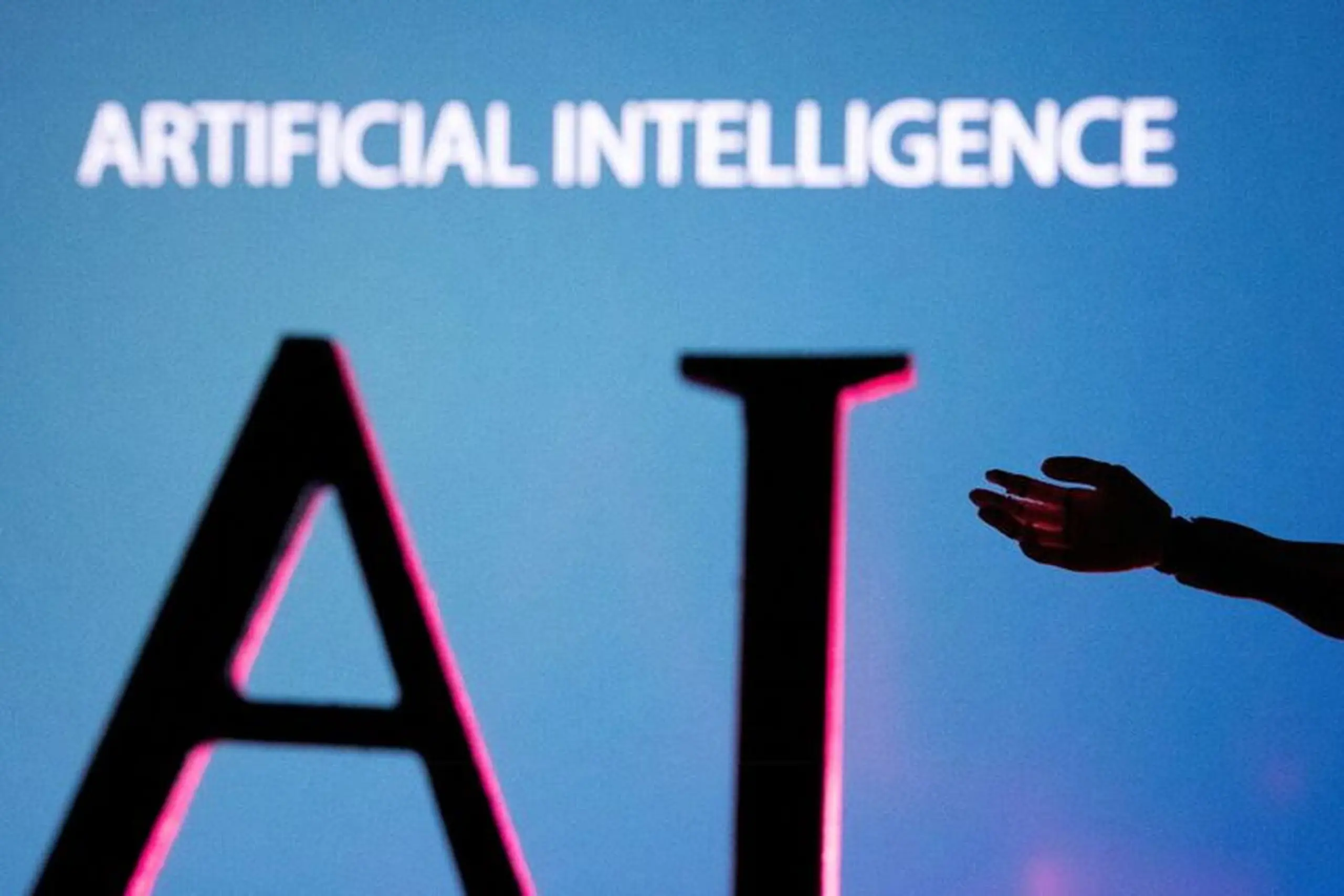 A hand reaches towards large "AI" letters with "ARTIFICIAL INTELLIGENCE" written above.