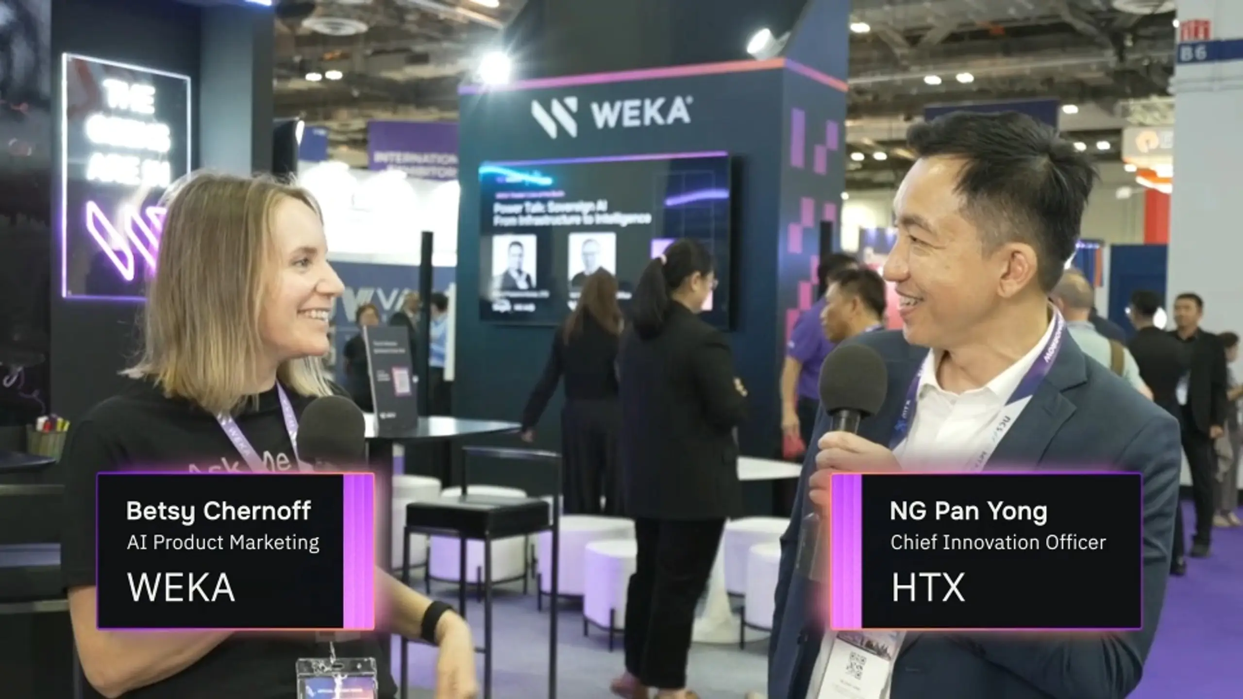Two people, Betsy Chernoff (WEKA) and Ng Pan Yong (HTX), are being interviewed with microphones at a conference.