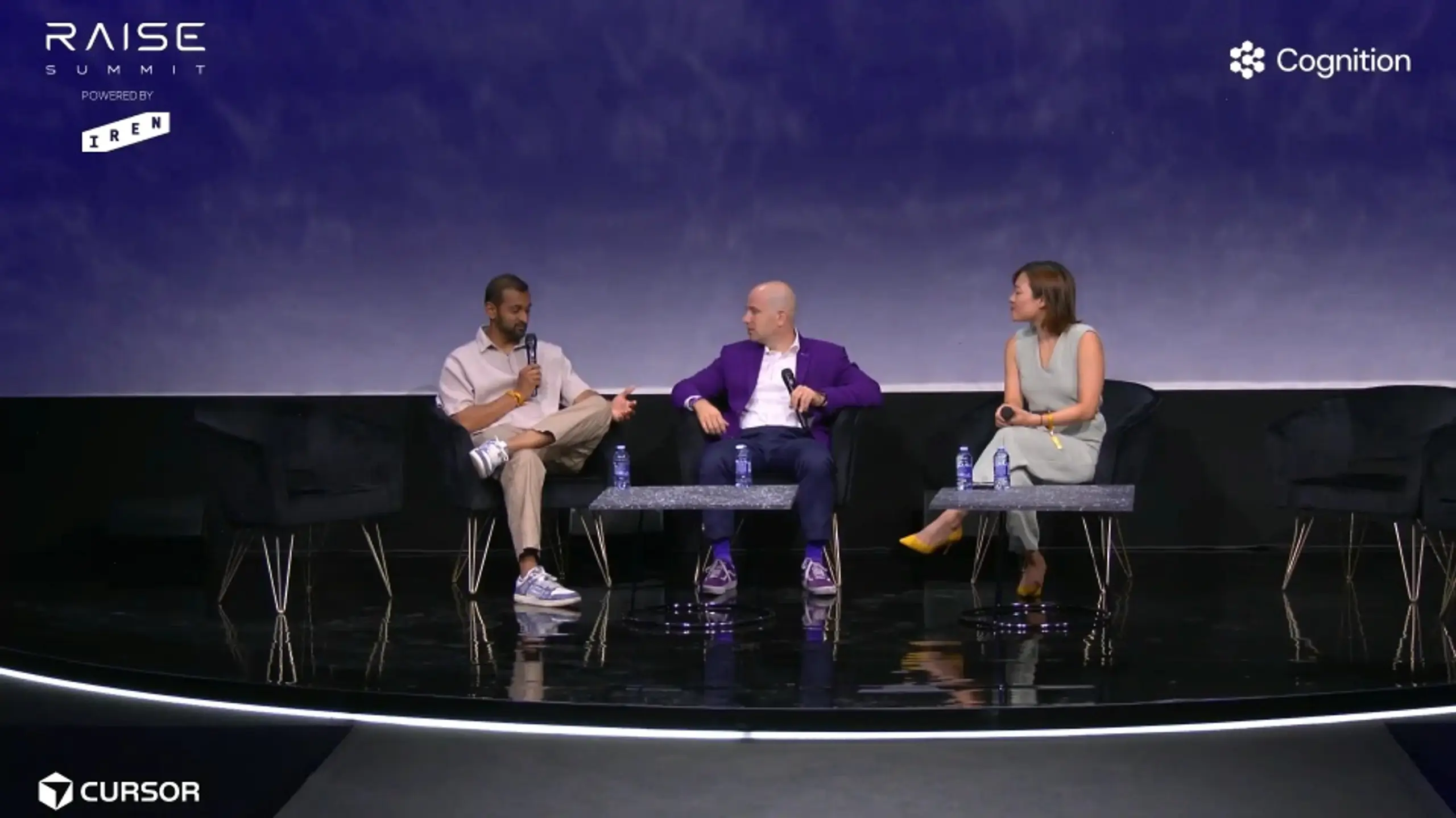 Three speakers on a stage during a panel discussion.