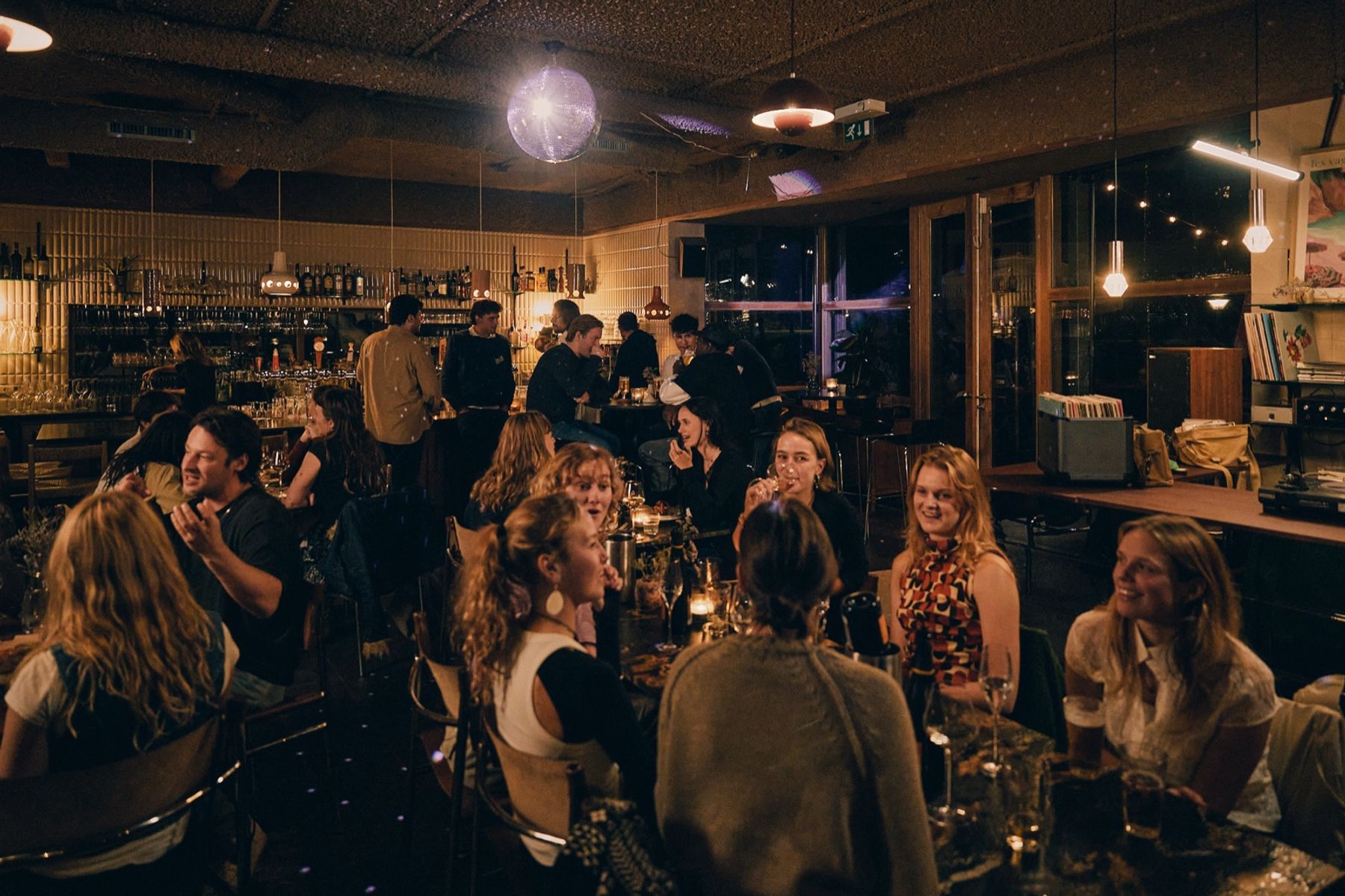 Gasten aan tafel tijdens een avond bij En Public