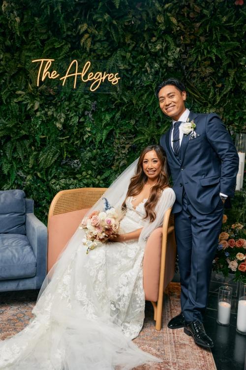 Wedding couple photographed against a custom branded backdrop — The Lounge Booth