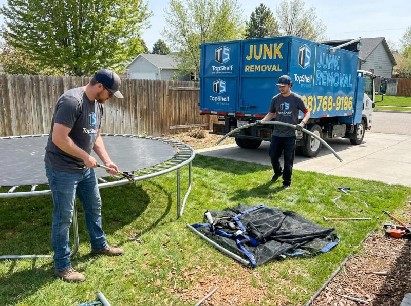 Top Shelf crew member loading a trampoline into the junk removal truck in Garden City Idaho