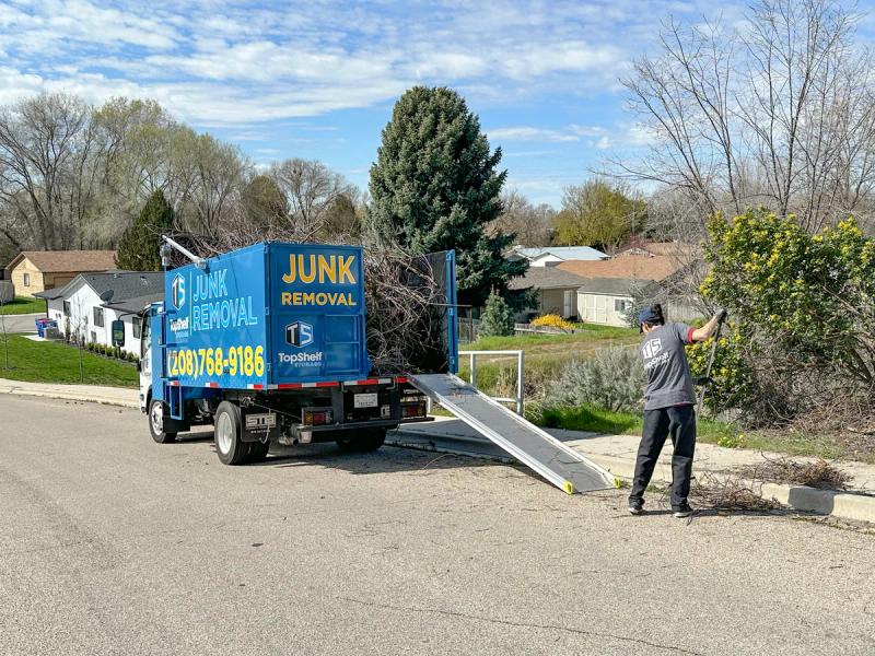 Top Shelf crew loading tree branches into the truck