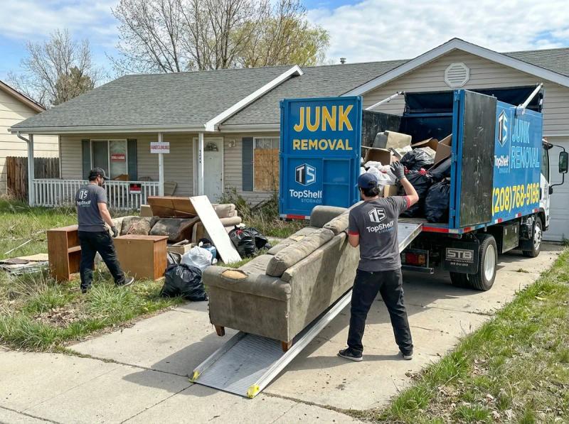 Top Shelf junk removal team hauling foreclosure property debris to the branded truck in Meridian Idaho