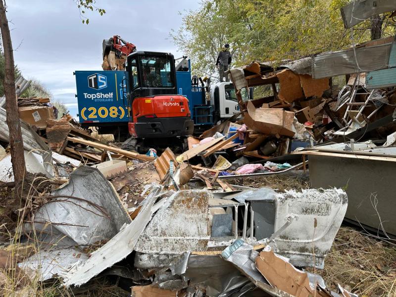 Top Shelf Kubota excavator working through a mobile home demolition debris pile in Boise Idaho