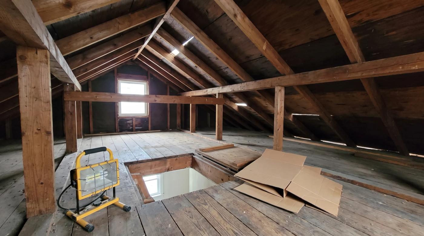 Cleared attic with exposed rafters and an open hatch after an attic cleanout at a home in Kuna, Idaho