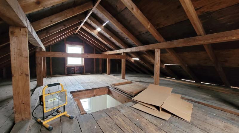 Cleared attic with exposed rafters and an open hatch after an attic cleanout at a home in Kuna, Idaho