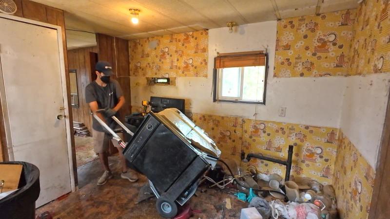 Top Shelf crew member removing old dishwasher from kitchen using a dolly in Meridian Idaho