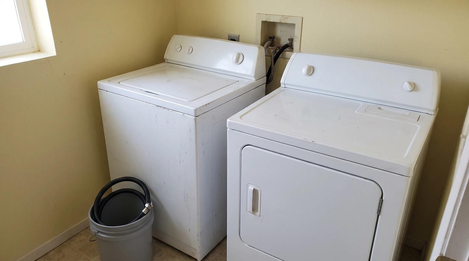 Old washer and dryer disconnected and ready for junk removal in a Boise, Idaho laundry room