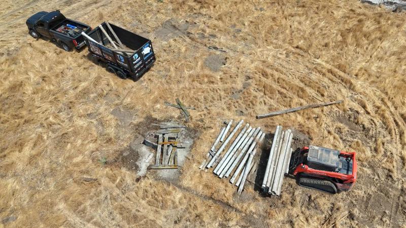 Aerial view of concrete post removal with skid steer and truck in Meridian Idaho