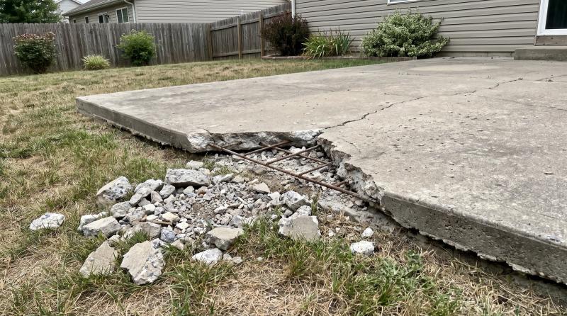 Broken concrete patio slab with exposed rebar and a pile of concrete chunks during a concrete removal job in Boise, Idaho