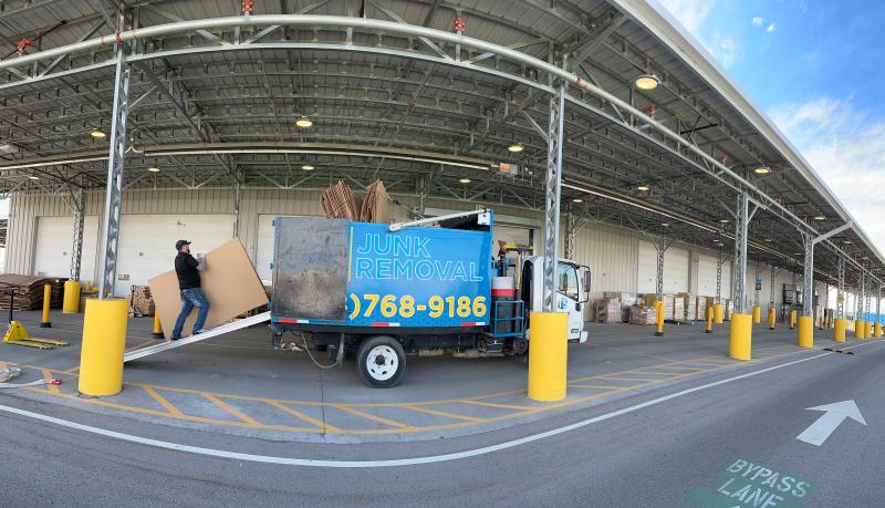 Top Shelf branded junk removal truck parked at a warehouse loading dock during a commercial cardboard cleanout in Star Idaho