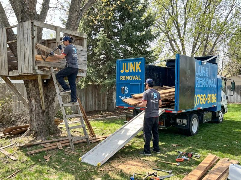 Top Shelf junk removal team loading demolished tree fort materials into the branded truck in Emmett Idaho