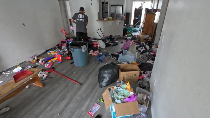 Top Shelf crew member clearing out a hoarded living room filled with household items in Meridian Idaho