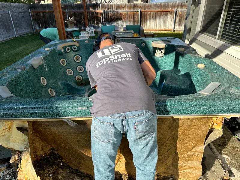 Top Shelf crew sawing apart a hot tub during removal in Nampa Idaho