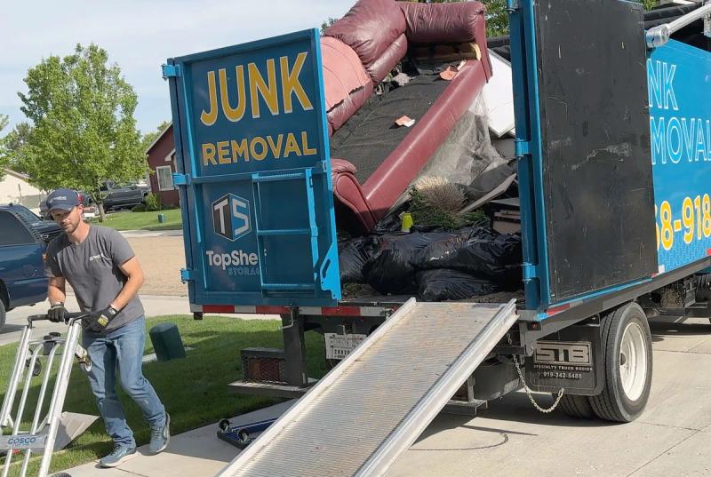 Top Shelf crew loading furniture and junk into truck during apartment cleanout in Meridian Idaho