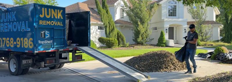 Bags of rock being loaded onto the Top Shelf branded truck at a residential property