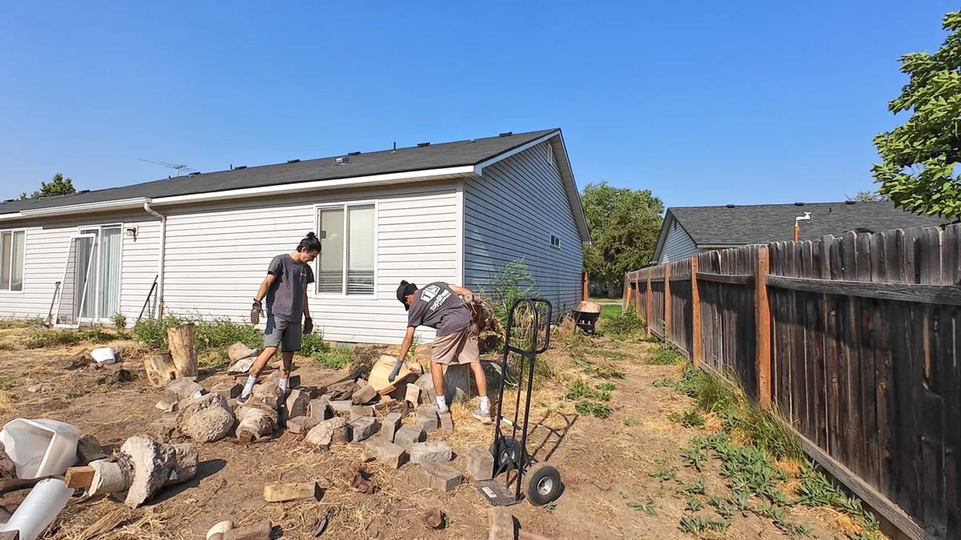 Top Shelf crew clearing broken concrete from a patio