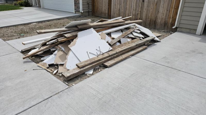 Pile of drywall and lumber construction debris ready for cleanup on a driveway in Nampa, Idaho