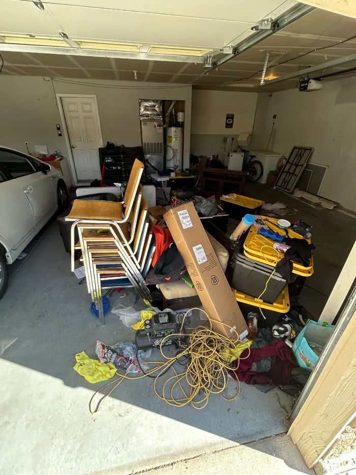 Two-car garage packed with chairs, boxes and clutter before a garage cleanout