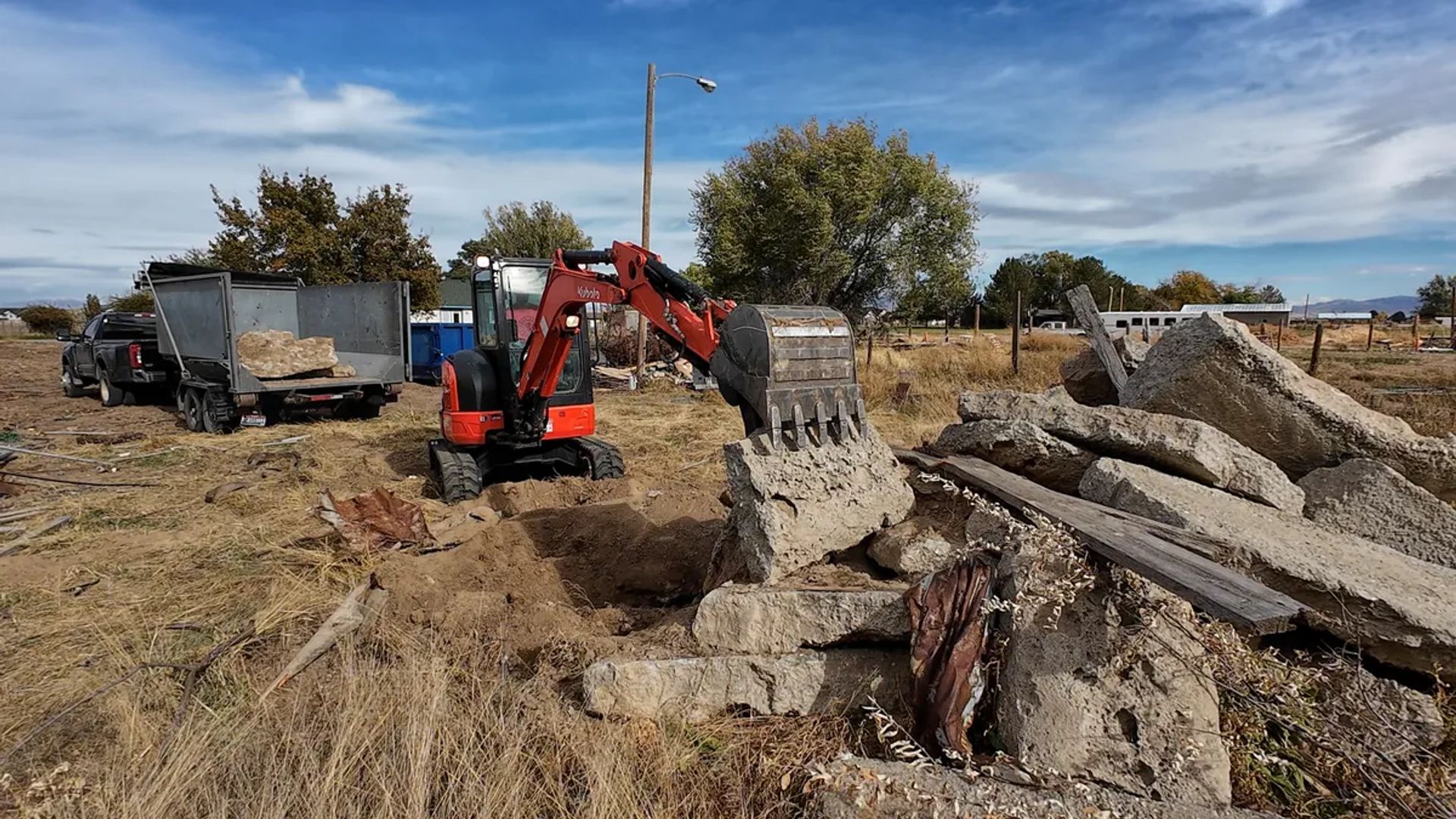 Top Shelf excavator breaking out an old concrete driveway