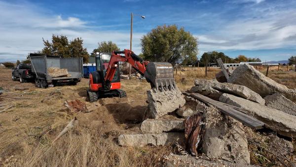 Top Shelf excavator breaking out an old concrete driveway