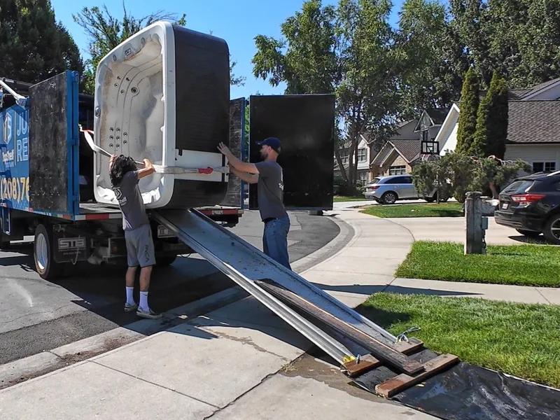 Two crew members loading a hot tub onto the Top Shelf truck in Eagle Idaho
