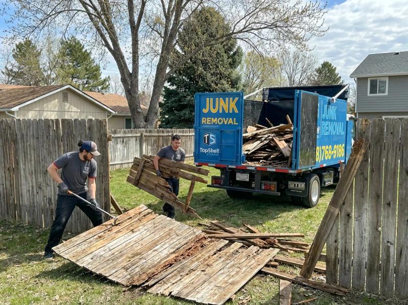 Top Shelf crew member using tools to dismantle an old fence in Garden City Idaho