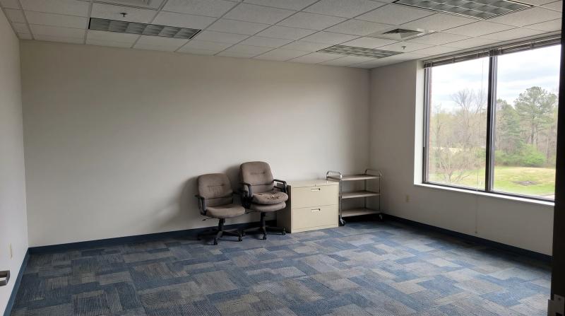Empty office suite during a commercial property cleanout in Boise, Idaho, with stacked office chairs and a filing cabinet ready to haul
