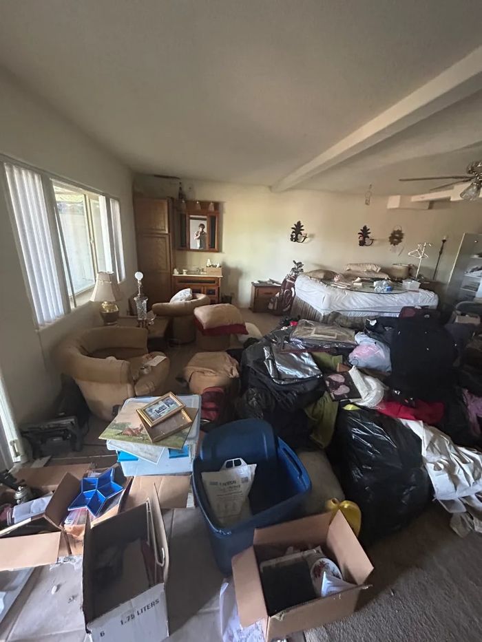Furnished room with bags and boxes before an estate cleanout
