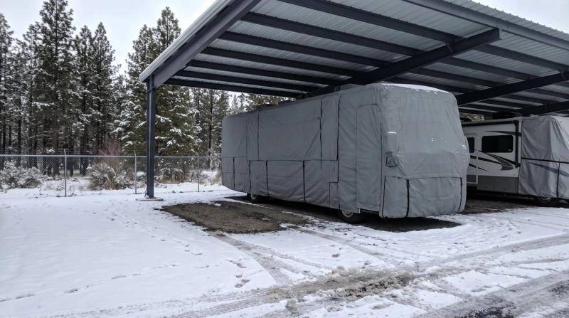 A motorhome under a winter cover at the storage lot
